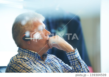 Senior businessman, headphones and thinking at call center for decision, choice or customer service at office. Mature man, consultant or agent in wonder or thought for online advice or help workplace 139304509