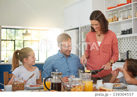 Love, breakfast and morning with a family in the dining room of their home together for health or nutrition. Mother, father and sibling children eating food at a table in their apartment for bonding Love, breakfast and morning with a family in the dining room of their home together for health or nutrition. Mother, father and sibling children eating food at a table in their apartment for bonding 139304557
