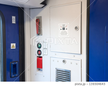 Interior view of train carriage doors with multilingual instructions and safety signage, emphasizing safe travel procedures and operational elements 139304643