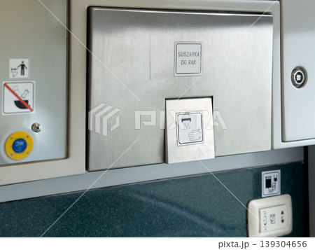 Brushed stainless steel hand dryer unit with clear signage indicating its function and intended use in a public restroom environment 139304656