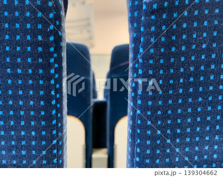 Closeup view of blue upholstered seats with small repeating square pattern in a public transport vehicle, conveying travel and commuting Closeup view of blue upholstered seats with small repeating square pattern in a public transport vehicle, conveying travel and commuting 139304662