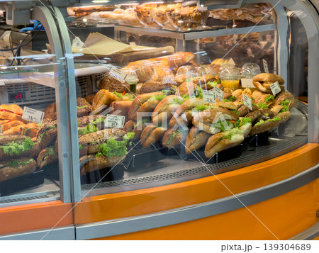 Assortment of freshly prepared sandwiches and pastries displayed in a refrigerated deli case for convenient grab-and-go meals Assortment of freshly prepared sandwiches and pastries displayed in a refrigerated deli case for convenient grab-and-go meals 139304689