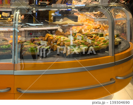 Freshly prepared sandwiches and baked goods displayed in a refrigerated bakery case, ready for sale to customers Freshly prepared sandwiches and baked goods displayed in a refrigerated bakery case, ready for sale to customers 139304690