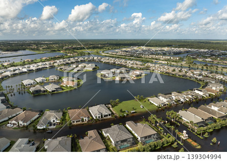 Flooding in Florida caused by tropical storm from hurricane rainfall. Suburb houses in residential community surrounded by flood waters. Aftermath of natural disaster Flooding in Florida caused by tropical storm from hurricane rainfall. Suburb houses in residential community surrounded by flood waters. Aftermath of natural disaster 139304994