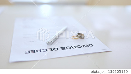 Divorce, contract and pen with wedding in office for signature, decision and break up of marriage. Closeup, document or legal paperwork and rings with trouble, problem or conflict in relationship Divorce, contract and pen with wedding in office for signature, decision and break up of marriage. Closeup, document or legal paperwork and rings with trouble, problem or conflict in relationship 139305150