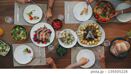 Family home, top view and food on table with hands, plate and dish for festive celebration. Vegetables, bread and chicken in dining room, house and people together for social holiday brunch at event 139305226