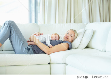 Relax, home and sofa, mother and baby bonding, woman and kid lying in living room together. Calm morning, mom and newborn on couch for rest, love and family security, comfort and child care in lounge Relax, home and sofa, mother and baby bonding, woman and kid lying in living room together. Calm morning, mom and newborn on couch for rest, love and family security, comfort and child care in lounge 139305262