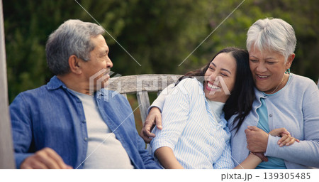 Senior, parents and woman in garden with hug, support and love in backyard and retirement. Happy family, elderly father and mother embrace daughter on bench in summer, park or bonding on vacation 139305485
