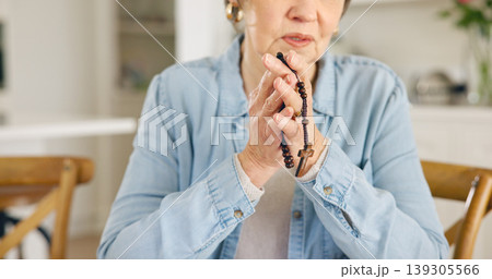 Closeup, old woman or rosary for prayer, faith or religion with guidance, spiritual or peace in a lounge. Apartment, pensioner or elderly person with beads, Christian or worship with Catholic or home 139305566