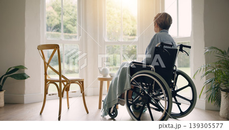 Wheelchair, old woman or thinking and lonely by window in nursing home or retirement with depression. Nostalgia, sad memory or depressed elderly person in lounge by an empty chair to remember past Wheelchair, old woman or thinking and lonely by window in nursing home or retirement with depression. Nostalgia, sad memory or depressed elderly person in lounge by an empty chair to remember past 139305577