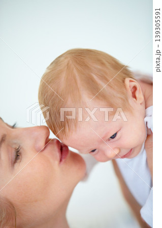 Mother, forehead and kiss baby with love for relax, care support and health wellness with parent happiness. Woman, holding and newborn with blonde hair, gratitude and security trust of maternal bond 139305591