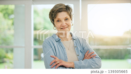 Senior woman, portrait and arms crossed in retirement, morning and home with happiness and health. Elderly, person and smile on face in house to relax with sunshine in apartment, lounge or vacation 139305665