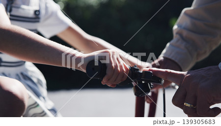 Parent, child and teaching bicycle ride for safety, closeup and outdoor street with hands. Cycling, childhood memory and riding in summer, bonding together and recreation with bike bell for alert Parent, child and teaching bicycle ride for safety, closeup and outdoor street with hands. Cycling, childhood memory and riding in summer, bonding together and recreation with bike bell for alert 139305683