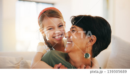 Child, grandmother and hug on sofa for laugh bonding, relax connection in retirement. Girl, old woman and embrace on couch for holiday rest or together in lounge for funny joke, love support or care 139305689