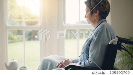Wheelchair, senior woman or thinking of memory by window in nursing home or retirement with depression. Grief nostalgia, sad history or lonely mature person in living room to remember past loss Wheelchair, senior woman or thinking of memory by window in nursing home or retirement with depression. Grief nostalgia, sad history or lonely mature person in living room to remember past loss 139305700