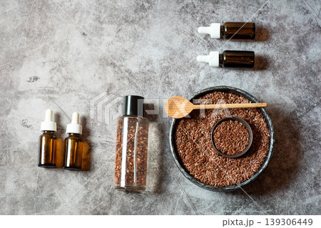 Flaxseed Oil and Seeds in Glass Bottles and Bowl on Gray Background 139306449