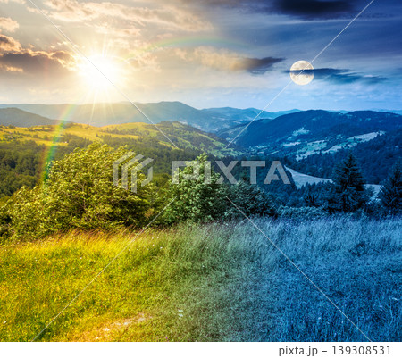 day meet night. agricultural field on hillside in mountains. sun and moon over carpathian mountain landscape on summer solstice. countryside view of alpine fields and rolling hills. epic sky 139308531