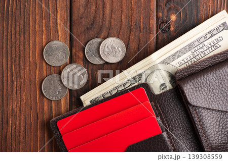 Leather Wallet with Cards, U.S. Dollar Cash and Coins on Dark Wooden Background Leather Wallet with Cards, U.S. Dollar Cash and Coins on Dark Wooden Background 139308559