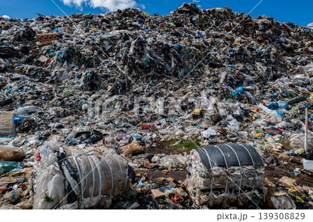Large piles of mixed waste including plastic and organic materials in an urban setting in daylight Large piles of mixed waste including plastic and organic materials in an urban setting in daylight 139308829