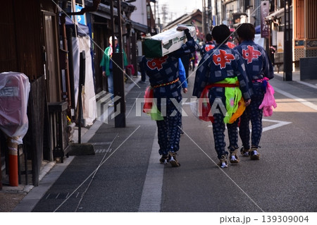 愛知県の犬山市　春の犬山祭りに参加する男性達　伝統的な法被と派手な帯を身に付け、城下町を歩く姿 139309004