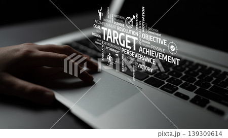 Close-up of a hand on a laptop keyboard with motivational words such as target, achievement, and perseverance visually highlighted in the background for inspiration. Tessel Close-up of a hand on a laptop keyboard with motivational words such as target, achievement, and perseverance visually highlighted in the background for inspiration. Tessel 139309614