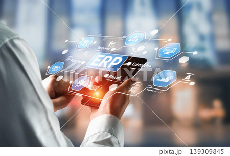 Business professional using mobile device to access enterprise resource planning software interface with digital icons and workflows in modern work environment. Tessel 139309845