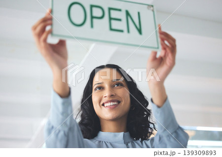 Woman, open sign and window store for company hours as professional owner, entrepreneur for customer notice. Female person, smile and holiday information for sales poster, service news for welcome Woman, open sign and window store for company hours as professional owner, entrepreneur for customer notice. Female person, smile and holiday information for sales poster, service news for welcome 139309893