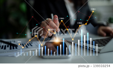 Business professional analyzing data trends with graphs and charts on a smartphone and laptop, focusing on financial growth and market insights Scalp 139310254