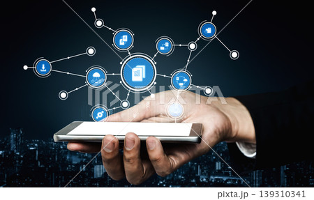 Modern Hand Holding Smartphone with Network Connection Icons Representing Digital Communication and Information Sharing in a Dark Urban Setting. Tessel Modern Hand Holding Smartphone with Network Connection Icons Representing Digital Communication and Information Sharing in a Dark Urban Setting. Tessel 139310341