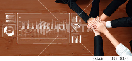 Hands Together with Data Analysis Graphs on Table for Team Collaboration and Business Strategy Planning in a Modern Office Setting Trope Hands Together with Data Analysis Graphs on Table for Team Collaboration and Business Strategy Planning in a Modern Office Setting Trope 139310385