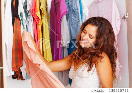 Woman, clothes and choice or happy in closet with morning routine, decision and outfit selection in bedroom of home. Person, face or smile with searching, style or clothing for fashion from wardrobe Woman, clothes and choice or happy in closet with morning routine, decision and outfit selection in bedroom of home. Person, face or smile with searching, style or clothing for fashion from wardrobe 139310751