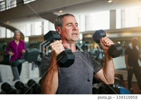 Old man, senior fitness and dumbbells at a gym for weightlifting, challenge or workout, training or bodybuilding. Biceps, arms and elderly person with hand weight for strength, mindset or exercise 139310958