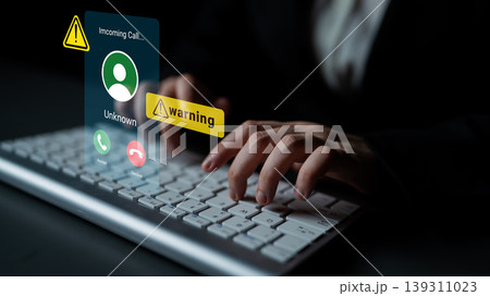 Alert Notification of Incoming Call with Warning Symbol Displayed on a Computer Screen While Hands Type on Keyboard Gantry 139311023