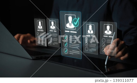 A businessman reviews holographic profiles while using a laptop and tablet, showcasing modern recruitment technology and data analysis methods for effective decision-making. Sigmoid 139311077