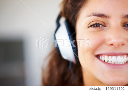 Smile, headphones and half face of woman listening to music, playlist or radio at home. Happy, technology and portrait of female person from Canada relax and streaming song or album in her apartment. Smile, headphones and half face of woman listening to music, playlist or radio at home. Happy, technology and portrait of female person from Canada relax and streaming song or album in her apartment. 139311392