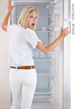 Woman, portrait and surprise with empty fridge in debt, financial crisis or stress in kitchen at home. Surprised or shocked young female person or blonde in bankruptcy, poverty or poor refrigerator Woman, portrait and surprise with empty fridge in debt, financial crisis or stress in kitchen at home. Surprised or shocked young female person or blonde in bankruptcy, poverty or poor refrigerator 139311434