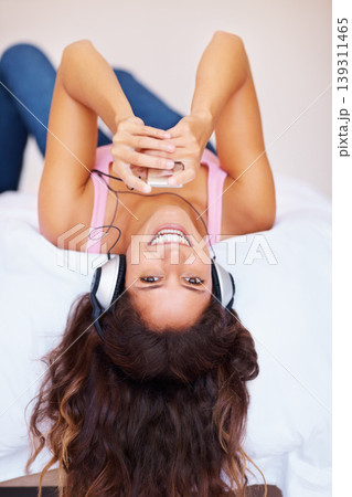 Happy woman, portrait and bed with headphones for music, relax or listening to podcast at home. Female person smile and lying with headset for audio streaming, sound or playing song album in bedroom Happy woman, portrait and bed with headphones for music, relax or listening to podcast at home. Female person smile and lying with headset for audio streaming, sound or playing song album in bedroom 139311465