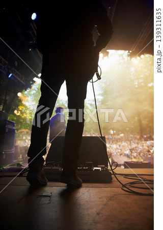 Musician, music festival and back on stage in outdoors, guitarist and event or energy for freedom at party. Person, concert or rave or performer, audio and playing or entertainment for audience Musician, music festival and back on stage in outdoors, guitarist and event or energy for freedom at party. Person, concert or rave or performer, audio and playing or entertainment for audience 139311635