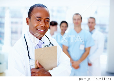 Doctor, black man and portrait of clipboard with medical, healthcare and clinic staff in a hospital. Teamwork, job and stethoscope of a nurse and surgeon with professional team ready for working Doctor, black man and portrait of clipboard with medical, healthcare and clinic staff in a hospital. Teamwork, job and stethoscope of a nurse and surgeon with professional team ready for working 139311874