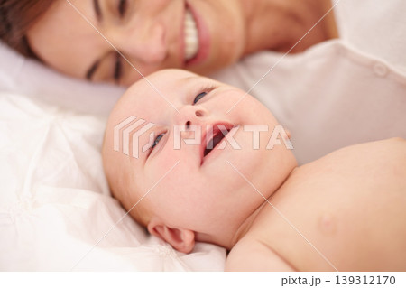 Mother, baby and happiness or love, care and relaxing on bed, bonding and joy in parenthood. Mom, newborn and peace or calm at home, positive and happy for child development, smile and rest together 139312170