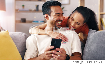 Happy couple, laughing and sofa with phone in home for comedy, social media or funny joke. Man, woman or hug with smile or mobile smartphone on couch for online subscription, app or humor in house Happy couple, laughing and sofa with phone in home for comedy, social media or funny joke. Man, woman or hug with smile or mobile smartphone on couch for online subscription, app or humor in house 139312171