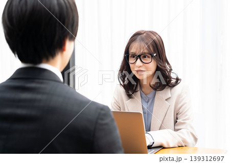 スーツを着た男性をカウンセリングする若い女性 スーツを着た男性をカウンセリングする若い女性 139312697