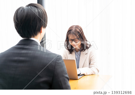 スーツを着た男性をカウンセリングする若い女性 スーツを着た男性をカウンセリングする若い女性 139312698