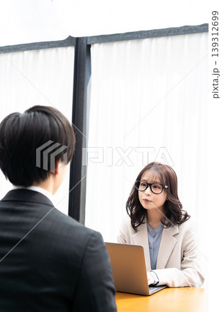 スーツを着た男性をカウンセリングする若い女性 139312699