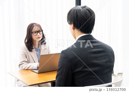 スーツを着た男性をカウンセリングする若い女性 139312700