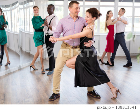 Middle-aged man and woman practicing waltz in dancing studio Middle-aged man and woman practicing waltz in dancing studio 139313341