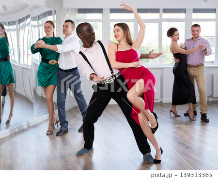 Man and young woman practicing waltz in dancing studio Man and young woman practicing waltz in dancing studio 139313365