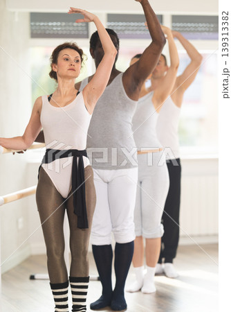 Female ballet teacher demonstrating third position at ballet class Female ballet teacher demonstrating third position at ballet class 139313382