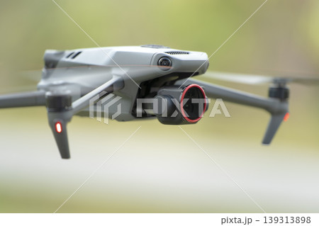 Drone quadcopter with digital camera and fast rotating propellers flying taking video and pictures Drone quadcopter with digital camera and fast rotating propellers flying taking video and pictures 139313898