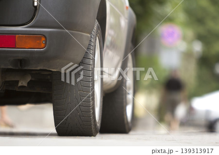 Detail of car, wheels with aluminum discs and new black rubber tire protector on light blurred background. Transportation, safety, reliability, modern design concept. Detail of car, wheels with aluminum discs and new black rubber tire protector on light blurred background. Transportation, safety, reliability, modern design concept. 139313917